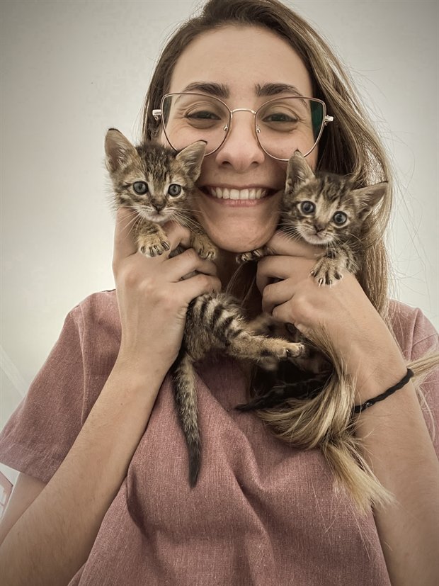 Dra. Carolina Lopes, veterinária domiciliar, segurando dois filhotes de gato